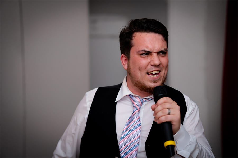 groom singing karaoke at wedding